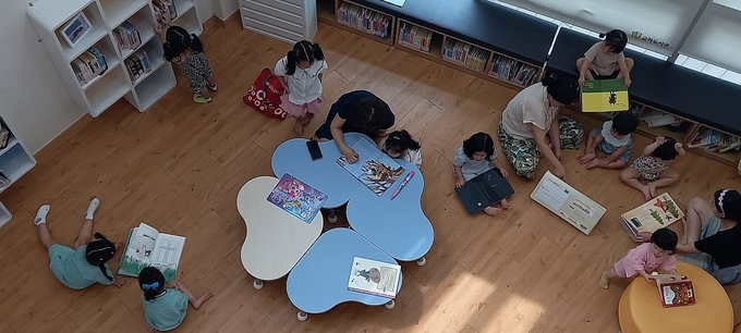 폭염이 지속되자 도서관을 찾는 시민들의 발길이 늘어나고 있다. 사진은 폭염을 피해 교하도서관을 찾은 부모와 자녀들이 함께 책을 읽고 있다. (사진=파주시 제공)<br>
