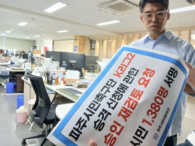 파주민네트워크 김성대 대표가 파주시가 추진하는 시민축구단 K리그2 승격에 재검토를 요구하는 시민들의 서명서를 받은뒤 대한축구협회에 전달하고 있다. (사진=파주시민네트워크 제공)<br>
