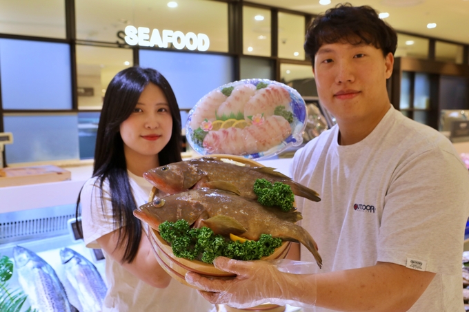  롯데백화점 본점 지하 1층에서 모델들이 제주산 붉바리를 들고 있다. (사진=롯데백화점 제공)