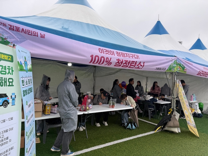 김포시민의 날을 맞아 100% 청정탄소 캠페인에 시민들의 참여하는 확인서를 쓰고 있다. (사진=김포시 제공)