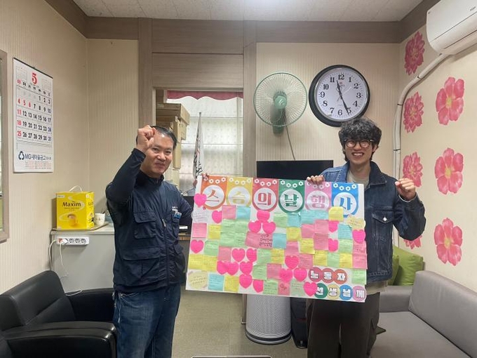  지난 5월 15일 스승의 날을 맞아 홍성호 아주대 노학연대 '가로등' 대표가 김홍구 청소노동자 노조 분회장에게 학생들이 쓴 편지를 전달하고 있다. (사진=아주대 노학연대 '가로등' 제공)