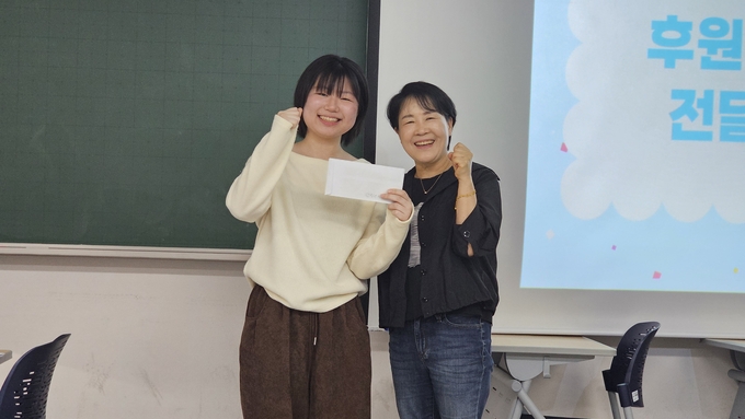  지난 5월 24일 정하늘 단국대 노학연대 '새벽' 대표가 김윤심 청소노동자 노조 분회장에게 학생들이 쓴 편지를 전달하고 있다. (사진=단국대 노학연대 '새벽' 제공)