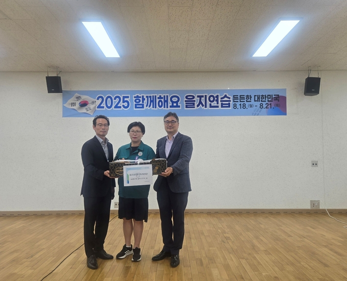 농협 구평회 시지부장이 을지훈련 관계들을 위해 준비한 컵과일 등의 음식을 광주시 관계자에게 전달하고 있다. (사진=NH농협은행 광주시지부 제공)