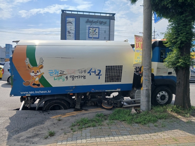땅꺼짐으로 인해 뒷바퀴가 빠진 청소차량. ( 사진 = 인천소방본부 제공 )