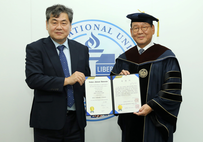 김교흥 국회의원(오른쪽)이 명예박사학위를 수여 받고, 이인재 인천대 총장(왼쪽)과 기념촬영을 하고 있다. ( 사진 = 인천대 제공 )
