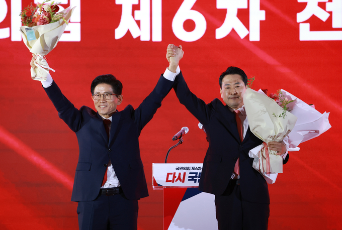 지난 22일 충북 청주 오스코에서 열린 국민의힘 제6차 전당대회에서 결선에 진출한 김문수, 장동혁 당대표 후보가 꽃다발을 받은 뒤 맞잡은 손을 들어 올리고 있다. (사진=연합뉴스)