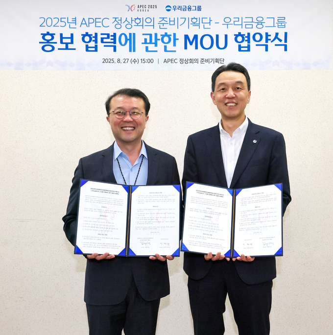 지난 27일 APEC 정상회의 홍보협력 업무협약식에서 김지준 APEC 정상회의 준비기획단 기획실장과 이정섭 우리금융지주 브랜드부문장이 기념사진을 촬영하고있다. (사진=우리금융그룹 제공)