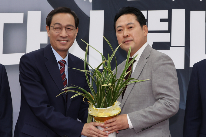 우상호 대통령실 정무수석이 지난 27일 국회에서 장동혁 국민의힘 신임 대표를 예방해 이재명 대통령이 보낸 축하난을 전달하고 있다. (사진=연합뉴스)