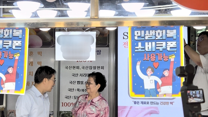 지난 20일 경기도 평택시 통복시장에서 ‘민생회복 소비쿠폰 사용 가능’ 안내문이 걸린 떡집에서 김동연 경기도지사가 상인과 대화를 나누고 있다. (사진=이유림 기자)