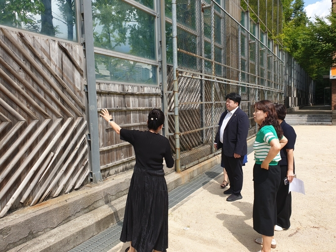 지난달 29일 배지환 수원시의원이 매탄중학교 운동장 외곽 방음벽의 노후화 및 탈락 현상을 점검하고 있다. (사진=수원시의회 제공)