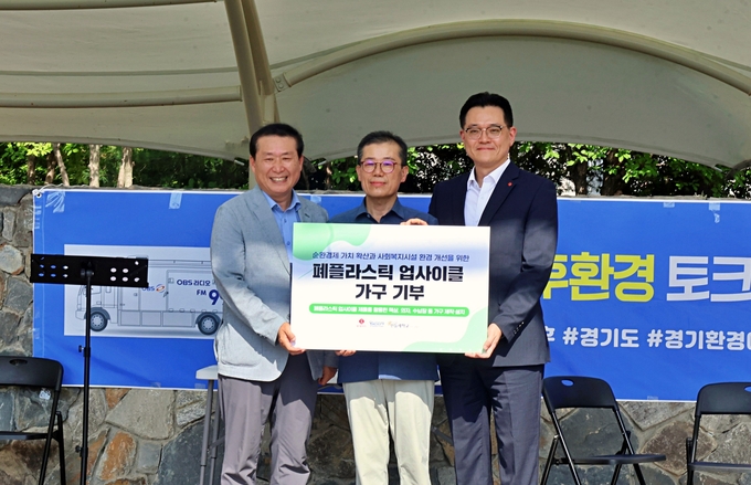 지난 5일 구리시에 위치한 구리광장에서 진주태 롯데마트·슈퍼 준법지원부문장(오른쪽)과 김준현 경기환경에너지진흥원 본부장(왼쪽), 이양현 구리남양주민들레학교장(가운데)이 '폐플라스틱 업사이클 시설물(가구) 전달식'을 진행하고 기념 사진을 촬영하고 있다. (사진=롯데마트 제공)