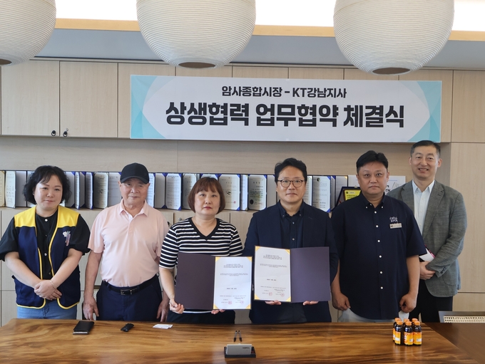 암사종합시장 상인회 심인숙 회장(가운데 기준 왼쪽)과 서은택 KT강남지사 지사장(가운데 기준 오른쪽)이 전통시장 통신환경 개선을 위한 업무협약을 체결한 뒤 기념촬영을 하고 있다. (사진=KT 제공)
