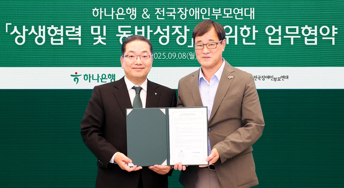지난 8일 하나은행은 오후 서울 삼성동 Place1에서 이호성 하나은행장(사진 왼쪽)이 윤종술 전국장애인부모연대 회장과 협약서를 들고 기념촬영을 하고 있다.