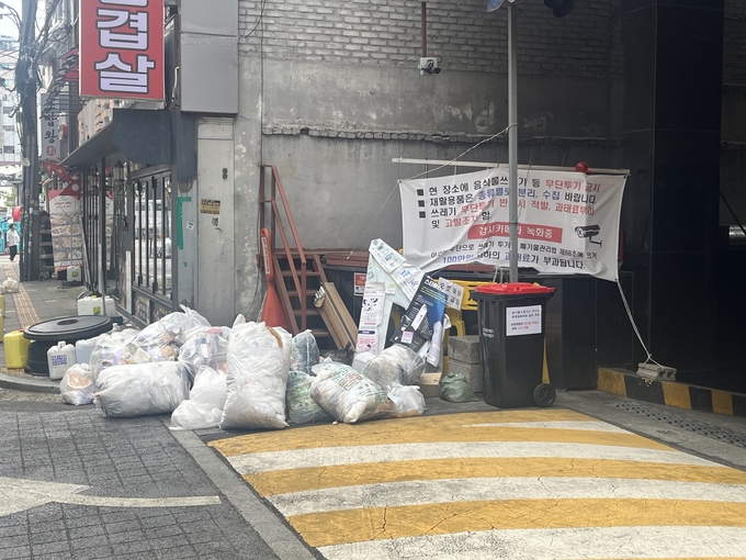  9일 오전 수원역 로데오거리에 부착된 '쓰레기 무단투기 금지' 현수막 앞에 다량의 쓰레기가 쌓여있다. (사진=안규용 기자)