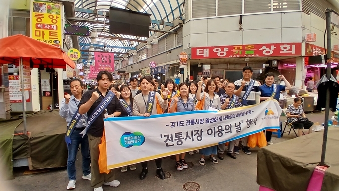 10일 안양 중앙시장에서 중앙시장 상인회와 경상원 남부총괄센터, 소상공인팀 등 관계자들이 ‘전통시장 이용의 날’ 행사를 열고 기념촬영을 하고 있다. (사진=경상원 제공)
