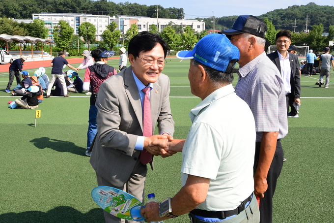 박용철 강화군수가 어르신에게 악수를 건네며 무상택시 사업 시행을 홍보하고 있다. ( 사진 = 강화군 제공 )