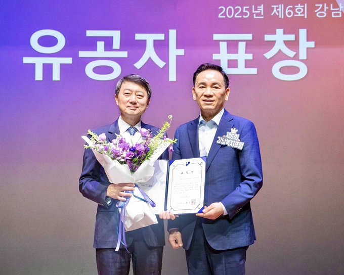 11일 서울 강남구 역삼문화센터에서 진행한 ‘제6회 강남복지포럼’에서 장호진 현대지에프홀딩스 사장(사진 왼쪽), 조성명 강남구청장(사진 오른쪽)이 표창 수여식을 마치고 기념사진을 촬영하고 있다. (사진=현대백화점그룹 제공)