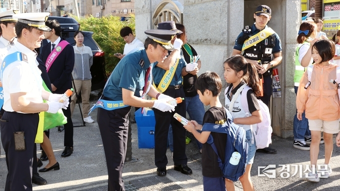 안성경찰서 김기범 서장이 교통안전 캠페인에서 어린이에게 홍보물을 전달하고 있다. (사진=안성경찰서 제공)