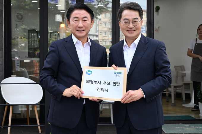 김동근 의정부시장(왼쪽)이 15일 미군 반환공여지 캠프 라과디아 부지에 들어선 ‘경기권 통일플러스센터’ 개관식에서 김동연 경기도지사(오른쪽)를 만나 의정부 발전을 위한 주요 현안이 담긴 건의서를 전달하고 있다. (사진=의정부시 제공)
