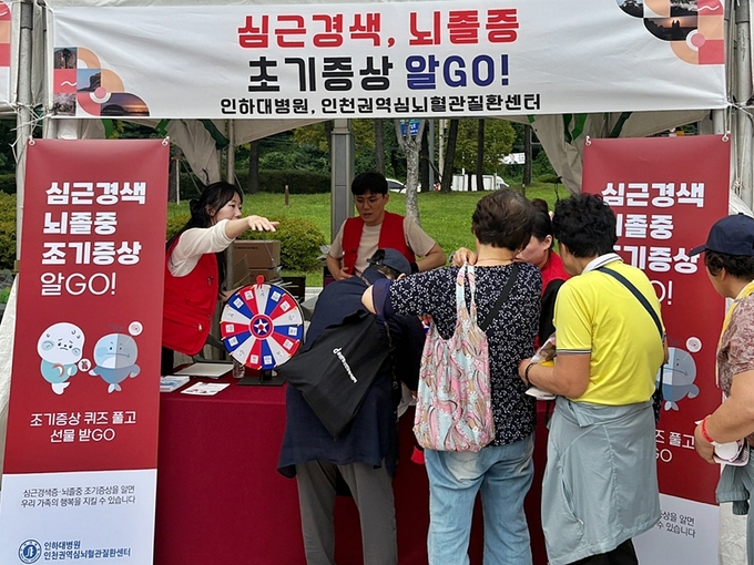 인하대병원 인천권역심뇌혈관질환센터가 옹진군민의 날 행사에서 심근경색·뇌졸중 조기증상 알리기 캠페인을 진행하며 주민들에게 건강 정보를 제공하고 있다. ( 사진 = 인하대병원 제공 )