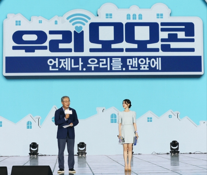 우리금융그룹 임종룡회장과 앰배서더 아이유가 지난 21일 우리모모콘 무대에서 우리원더패밀리 사업을 발표하고있다. (사진=우리금융그룹 제공)