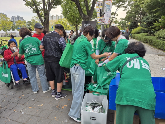 부천시 홍보대사 에녹의 팬카페 '화기에에' 회원들이 에녹 굿즈를 나눠주고 있다. (사진=반현 기자)
