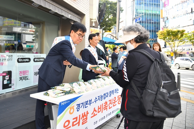 엄범식 농협중앙회 경기본부장이 수지구청역 사거리에서 백옥쌀을 나눠주고 있다. (사진=경기농협 제공) 