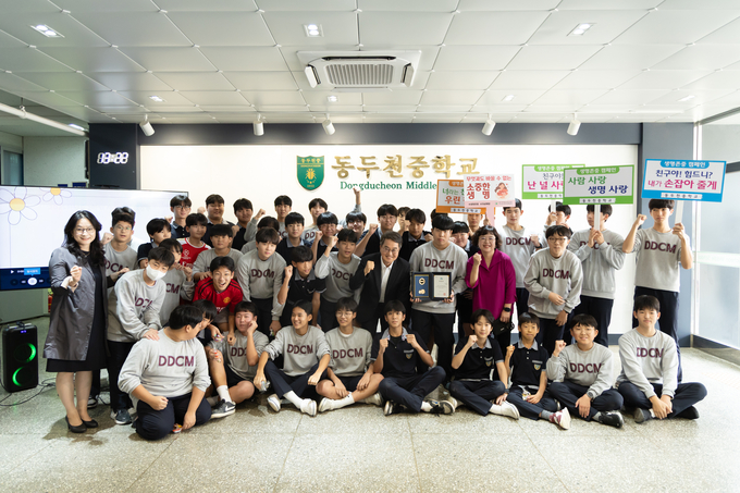 16일 김동연 경기도지사가 노점 할머니께 비상금을 건넨 선행으로 화제를 모은 동두천중학교 옥현일 군에게 표창을 수여한 뒤 학생들과 가념촬영을 하고 있다. (사진=경기도 제공)