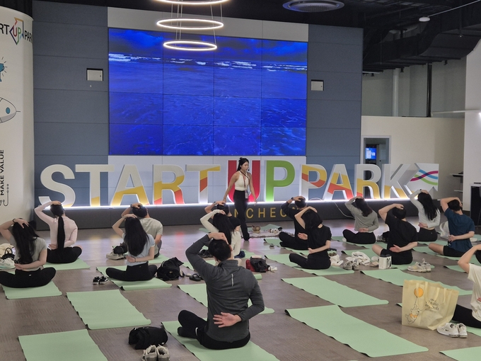 지난 18일 인천 송도 스타트업파크에서 열린 '2025 웰니버스 인천'에서 조한솔 전문 강사의 지도에 따라 시민들이 몸을 풀고 있다. ( 사진 = 정진영 기자 )