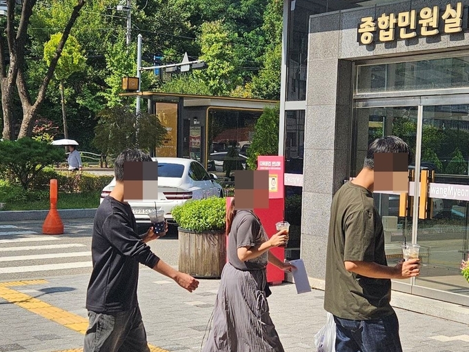 경기도 내 한 시군 소속 직원들이 일회용 컵을 들고 청사를 향하고 있다. (사진=경기환경운동연합 제공)