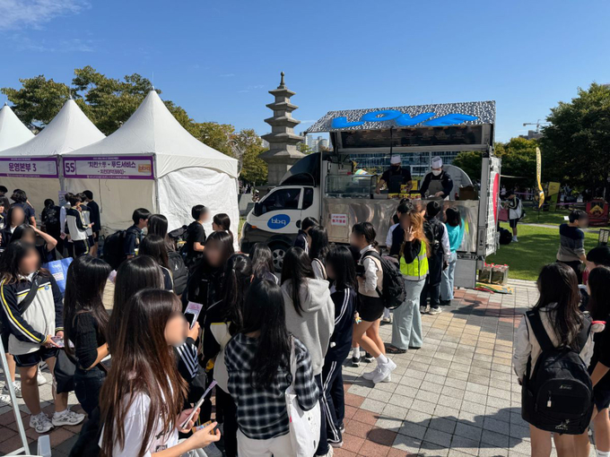 지난 17일 이천시청 앞 광장 일대에서 진행된 ‘2025 이천시 청소년진로체험박람회’에서 BBQ가 찾아가는 치킨릴레이로 치킨을 기부했다. (사진=제너시스BBQ 그룹 제공)