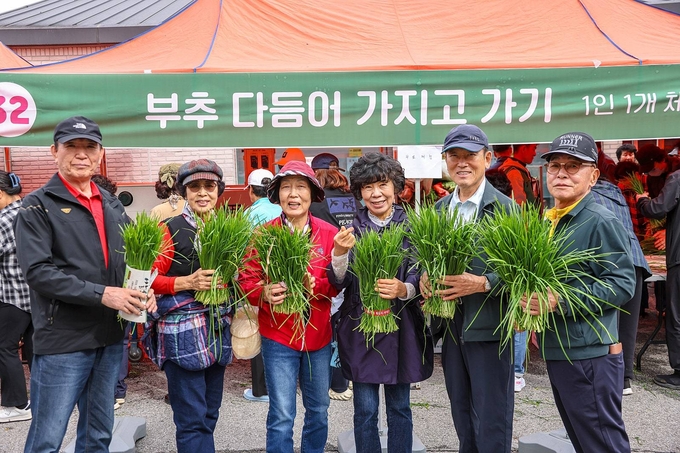 양평부추축제추진위원회가 부추를 들고 기념촬영을 하고 있다. (사진=양평군 제공)