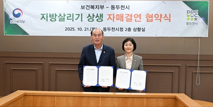 박현덕 동두천시장(좌측)과 이스란 보건복지부 1차관이 협약서를 들어보이고 있다. (사진=동두천시 제공) 