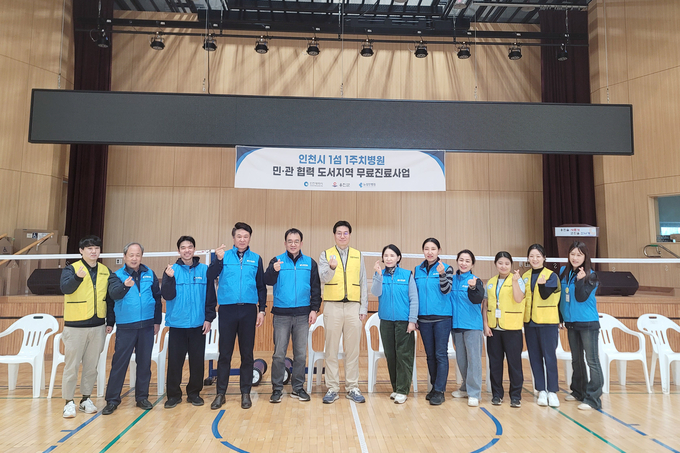 뉴성민병원 관계자들이 지난 21일 북도면 국민체육센터에서 주민 진료 후 기념촬영을 하고 있다. (사진=옹진군 제공) 