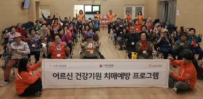 <strong>시립광진노인복지관 '어르신 건강기원 치매예방 프로그램'에 참여한 어르신들이 기념촬영을 하고 있다. (사진=KB국민은행 제공)</strong>