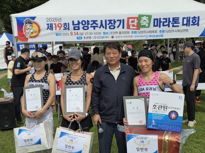 제19회 남양주시장기 단축마라톤대회에서 문정만 회장이 선수들과 기념촬영을 하고 있다.(사진=문정만 회장 제공)