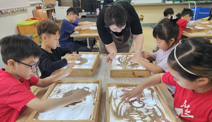  매현초등학교 1학년 아이들이 샌드아트 드로잉을 하고 있다. (사진=매현초등학교 제공)