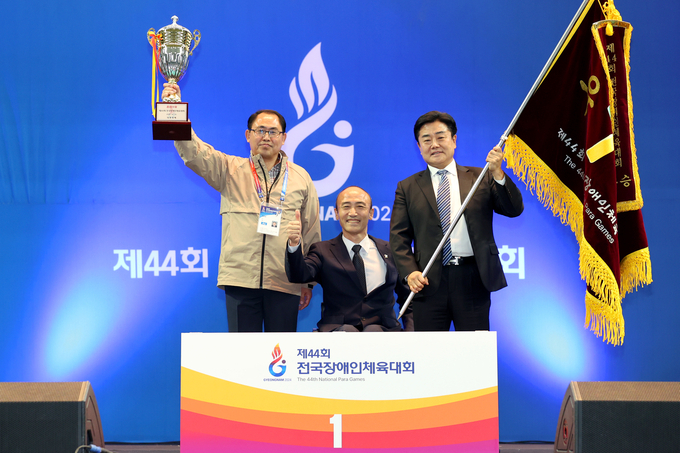 지난해 '제44회 전국장애인체육대회'에서 종합우승을 차지한 경기도장애인체육회 백경열 사무처장(오른쪽), 허범행 본부장(왼쪽)이 정진완 대한장애인체육회장과 기념사진을 찍고 있다. (사진=대한장애인체육회 제공)