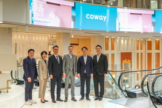 28일 협약식에서 김순태 코웨이 경영관리본부장(왼쪽)과 황웨이 제주신화월드 CEO(오른쪽)가 기념촬영을 하고 있다. (사진=코웨이 제공)