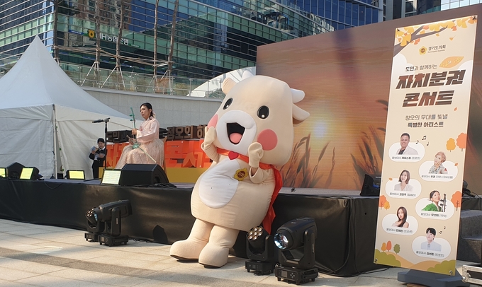 29일 경기융합타운광장 도담뜰에서 열린 ‘2025 도민과 함께하는 정오의 하모니 자치분권 콘서트’에서 경기도의회 마스코트 소원이가 음악공연을 관람하고 있다. (사진=나규항 기자)