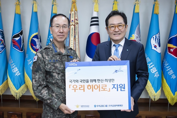 지난 28일 (왼쪽부터) 손석락 공군 참모총장과 장광익 우리금융미래재단 사무국장이 계룡대에서 공군에게 지원금을 전달하고 기념촬영을 했다. (사진=우리금융미래재단 제공)