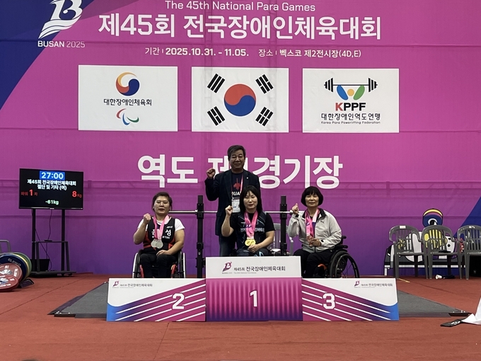 2일 부산 베스코 제2전시장에서 열린 '제45회 전국장애인체육대회' 3일째 역도 여자 55kg급 벤치프레스종합 OPEN(선수부) 에서 한국신기록 3개를 작성한 신윤기(가운데·경기도)가 기념사진을 찍고 있다. (사진=경기도장애인역도연맹 제공)