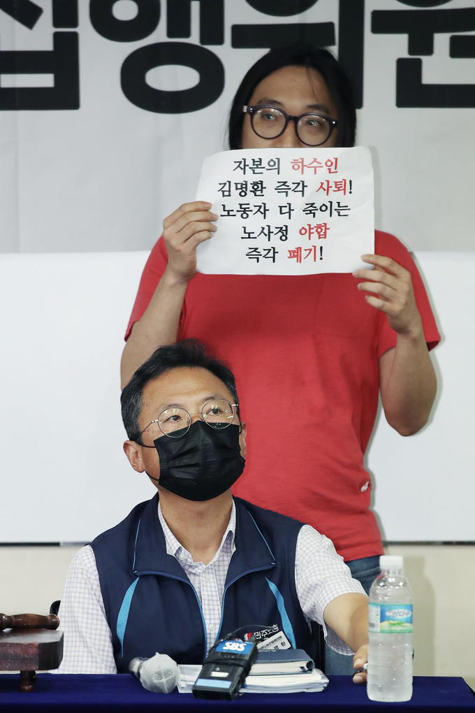 김명환 민주노총 위원장과 노사정 합의 반대 손팻말 든 조합원. (사진=연합뉴스 제공)