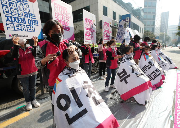 전국학교비정규직노동조합 초등돌봄전담사들이 지난달 27일 오전 서울 여의도 민주당 중앙당사 앞에서 열린 11·6 돌봄파업 선포 기자회견에서 집단 삭발식을 하고 있다. (사진=연합뉴스 제공)
