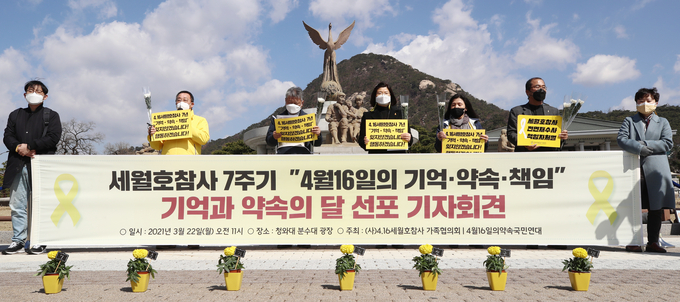 22일 오전 청와대 앞 분수대에서 열린 "세월호참사 7주기 '4월 16일의 기억·약속·책임' 기억과 약속의 달 선포 기자회견" 참석자들이 국화와 손피켓을 들고 있다. (사진=연합뉴스)