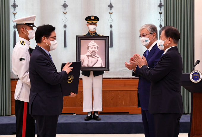  문재인 대통령이 17일 청와대에서 열린 고 홍범도 장군 훈장 추서식에서 홍범도장군기념사업회 우원식 이사장에게 건국훈장 대한민국장을 추서한 뒤 박수치고 있다. (사진=연합뉴스)