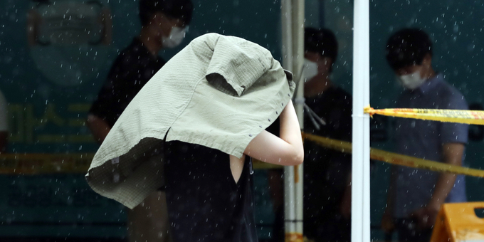 옷으로 우산을 (사진 = 연합뉴스 제공)
