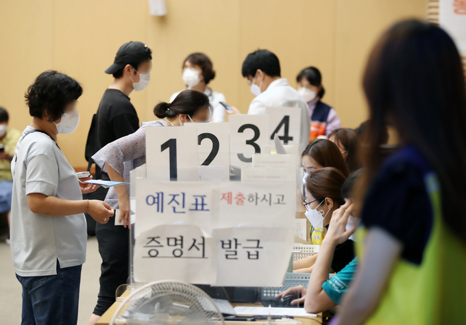 백신 접종 증명서 받는 시민들 (사진=연합뉴스 제공)