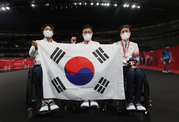30일 오전 일본 도쿄 메트로폴리탄체육관에서 열린 2020 도쿄 패럴림픽 남자 탁구 개인전(스포츠등급 1) 시상식이 끝난 뒤 금메달을 차지한 주영대(가운데), 은메달 김현욱(왼쪽), 동메달 남기원이 함께 태극기를 들고 포즈를 취하고 있다. (사진=연합뉴스)
