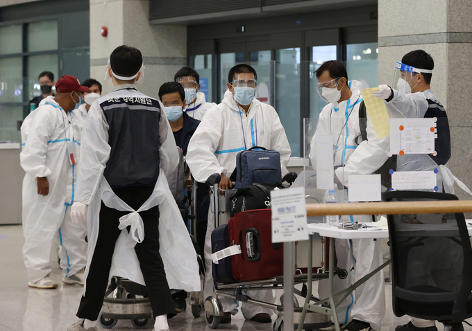 국내에서 신종 코로나바이러스 감염증(코로나19)의 새로운 변이 바이러스인 '오미크론 변이'에 감염된 사례가 확인된 가운데 2일 오전 인천국제공항을 통해 입국한 외국인들이 방역복을 착용한 채 입국장을 나서고 있다. 정부는 오미크론 변이의 추가 국내 유입을 막기 위해 향후 2주간 내국인을 포함한 모든 해외 입국자에 대해 예방접종 여부와 상관없이 10일 격리조치를 하기로 했다. (사진=연합뉴스)